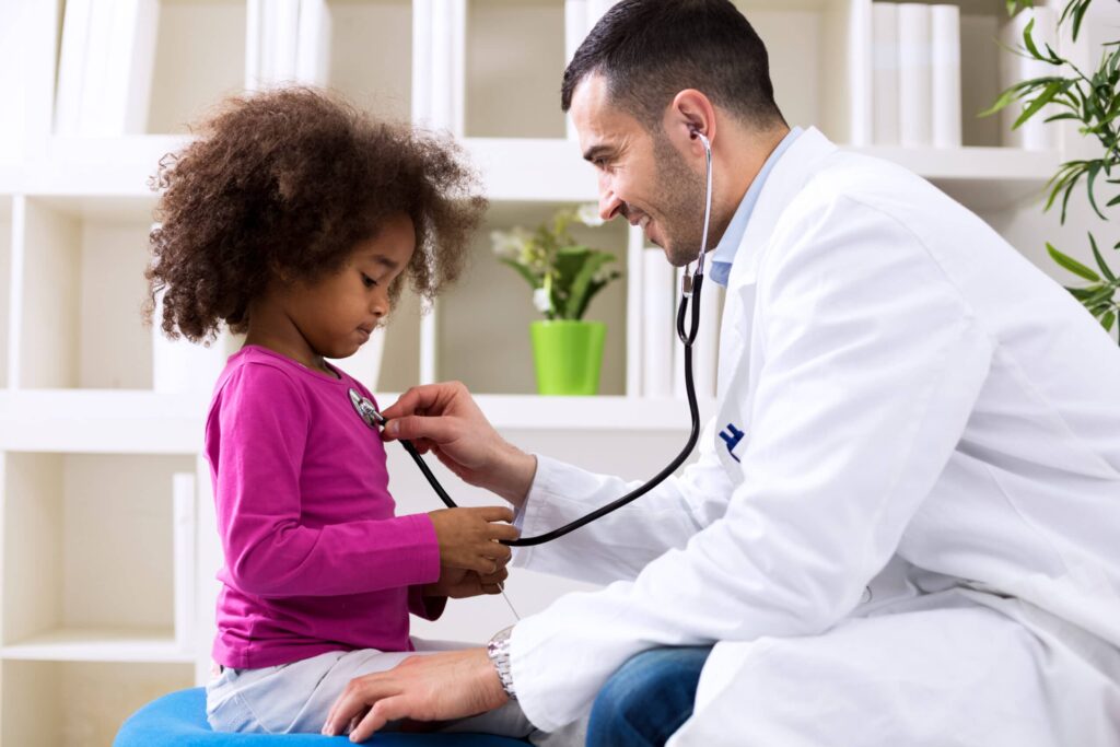 Pediatrician checking child's heartbeat