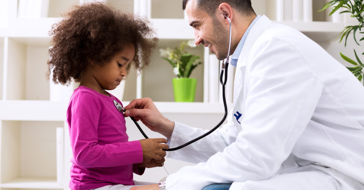 Pediatrician checking child's heartbeat