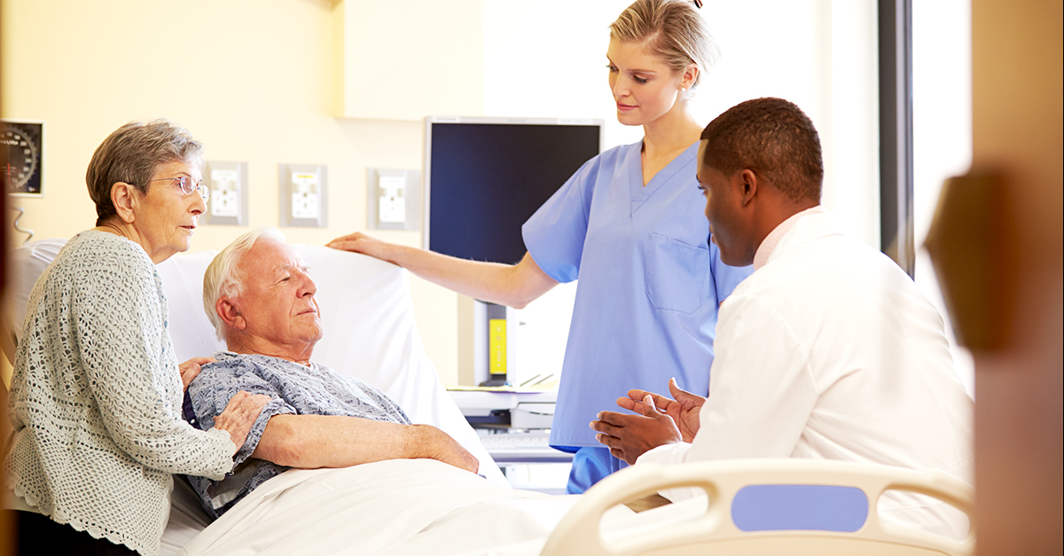 Doctor and nurse caring for elderly patient with family