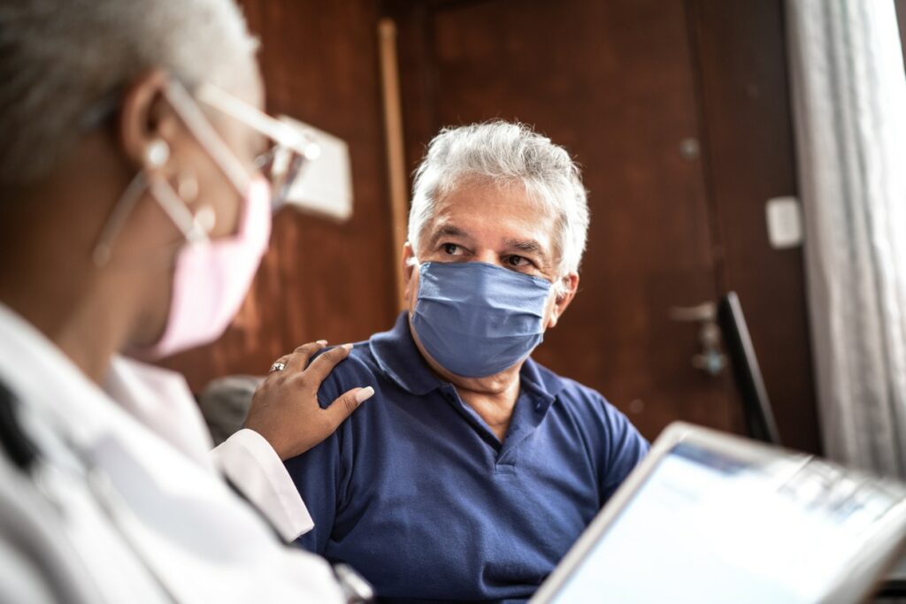 Doctor speaking to patient in mask