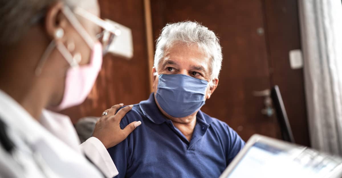 Doctor speaking to patient in mask
