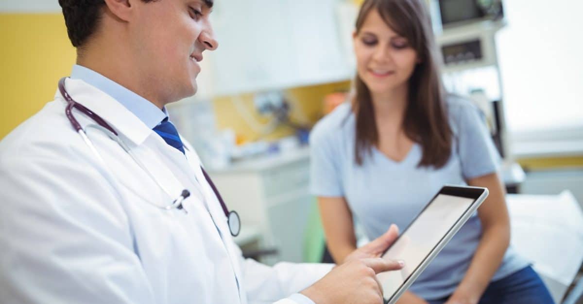 Doctor using digital tablet to improve patient experience