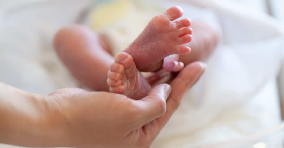 nurse holding up infant's feet